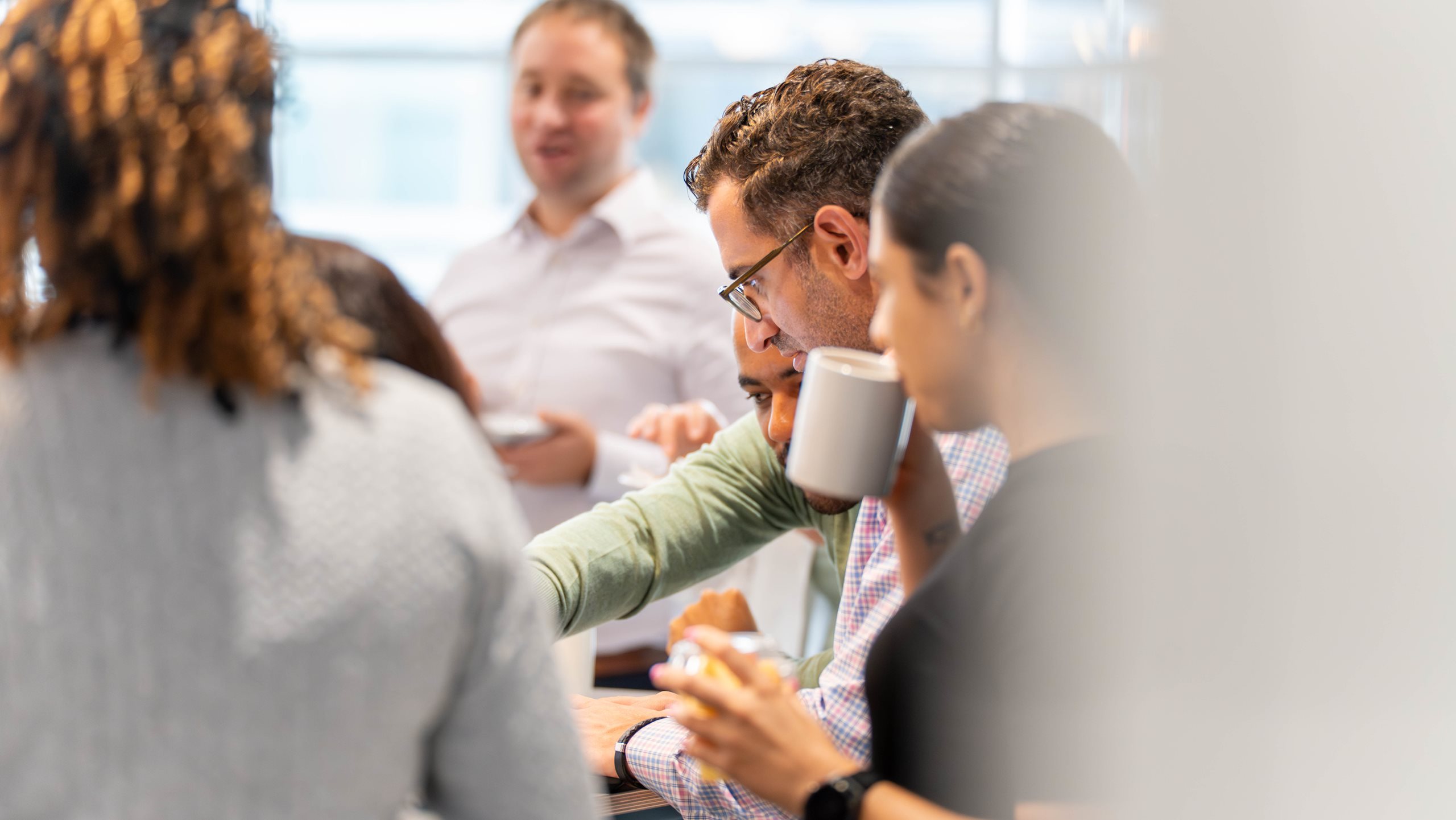 Audit team members having refreshments around the table in a breakout room