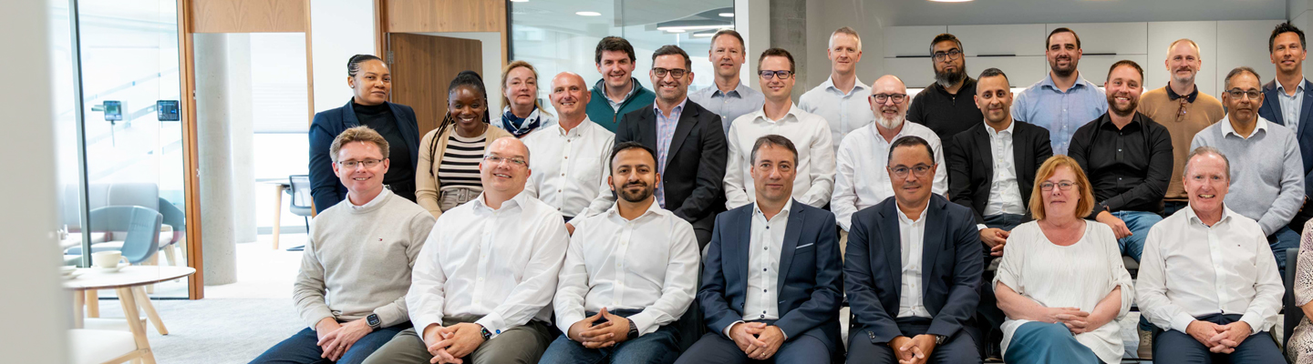 Large team of smiling colleagues, sitting together for a team photo