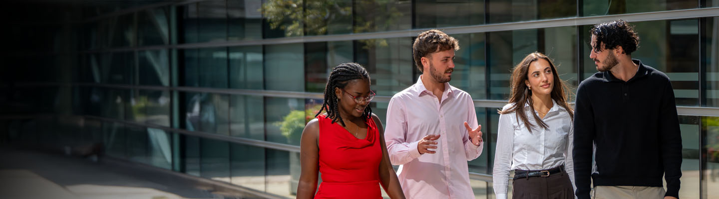 Group of smiling accountants walking together outside a new office.