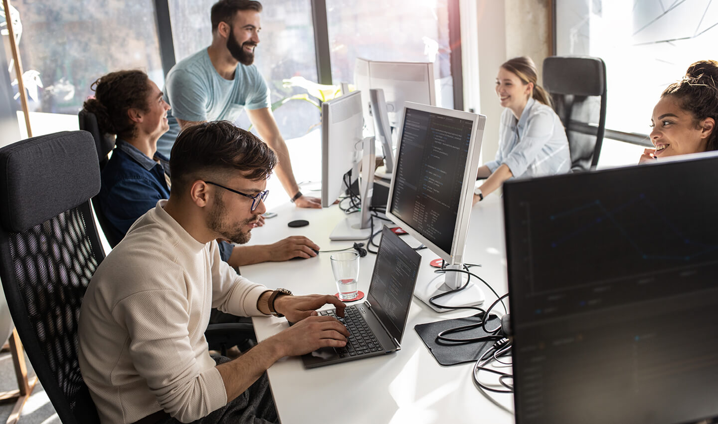 A team conducting a due dilligence process on thier laptops in a modern office