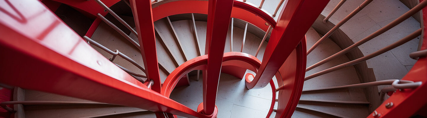 A top-down view of a red spiral staircase