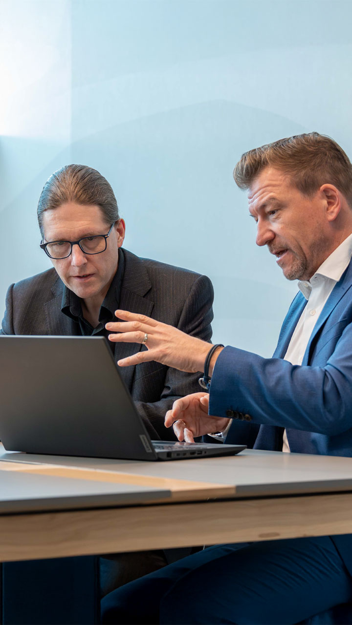 Two experienced consultants working together in a bright modern office.
