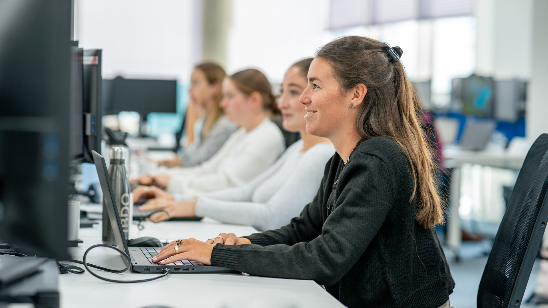 A row of junior team members at their workstations